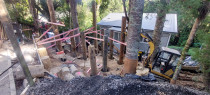 Installing Poles for a Parking Platform - Titirangi - Large poles with a small digger. Difficult, limited access job.