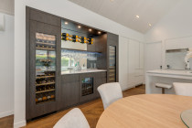 Innovative Kitchens - Project - It's always a pleasure to work on unique projects that require custom work. 
The Bespoke Champagne Bar is a great example of this. 
Our design features intricate detailing, luxurious finishes, and an ambience of sophistication that elevates this stunning home.
Rich oak panels, integrated appliances, and custom glass splash back, provide an exquisite space for entertaining guests in style. 
Soft, ambient lighting adds to the sophisticated atmosphere, making it the perfect setting for intimate gatherings and celebratory toasts.  
Designed by: Michelle Samuels