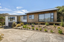Grand Architectural Extension - We dramatically expanded this home by designing and building a grand, light-filled extension.
Clad in stunning vertical cedar, the new addition creates a warm, contemporary statement that beautifully contrasts with the original home.
The new structure houses a significant living space, designed to seamlessly connect with the landscape.
Vast, floor-to-ceiling sliding doors and a low-profile deck merge the interior with the outdoors.
We ensured cohesive design by matching the new black joinery to the existing windows.
This project showcases how a bold, architectural addition can completely transform a home's scale, function, and style