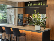 Innovative Kitchens - Project - This spectacular kitchen gives New York Loft vibes in this meticulously detailed and curated commercial building conversion. The owners of this city centre home had the vision to convert an office space into a luxurious retreat.  Combining concrete surfaces with crown cut veneer and Matt black acrylic doors, an oversized sculptural tap creates a textured feast for the senses. Blum Legrabox black drawers ensure that not an inch of space is wasted, and the kitchen is the centrepiece of this spectacular home. Hospitality is a breeze with this custom bar area housing wine, glasses, refrigerated drawers and wine fridge and a display space to feature the client’s heirloom decanters.
Designer: Lisa Thesing