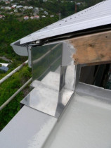 Stainless steel flashing by Buildstrong - Triangular window was leaking where it met the trafficgard deck and roof and wall cladding.  Fitted custom stainless steel flashing.