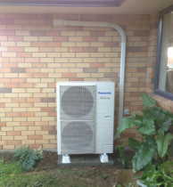 Domestic Install - Vincent Install Ltd - Panasonic E28NKR (9KW Heating) mounted using Pavers & Riser Feet.
Note the dedicated power supply coming in from the switchboard via roof space & the eave. The supply then runs in the trunking to the exterior mounted Isolator (On/Off Switch) before feeding the Heat Pump. In this installation both the condensate drain from the interior unit and the drain for the exterior unit are drained to the garden area.